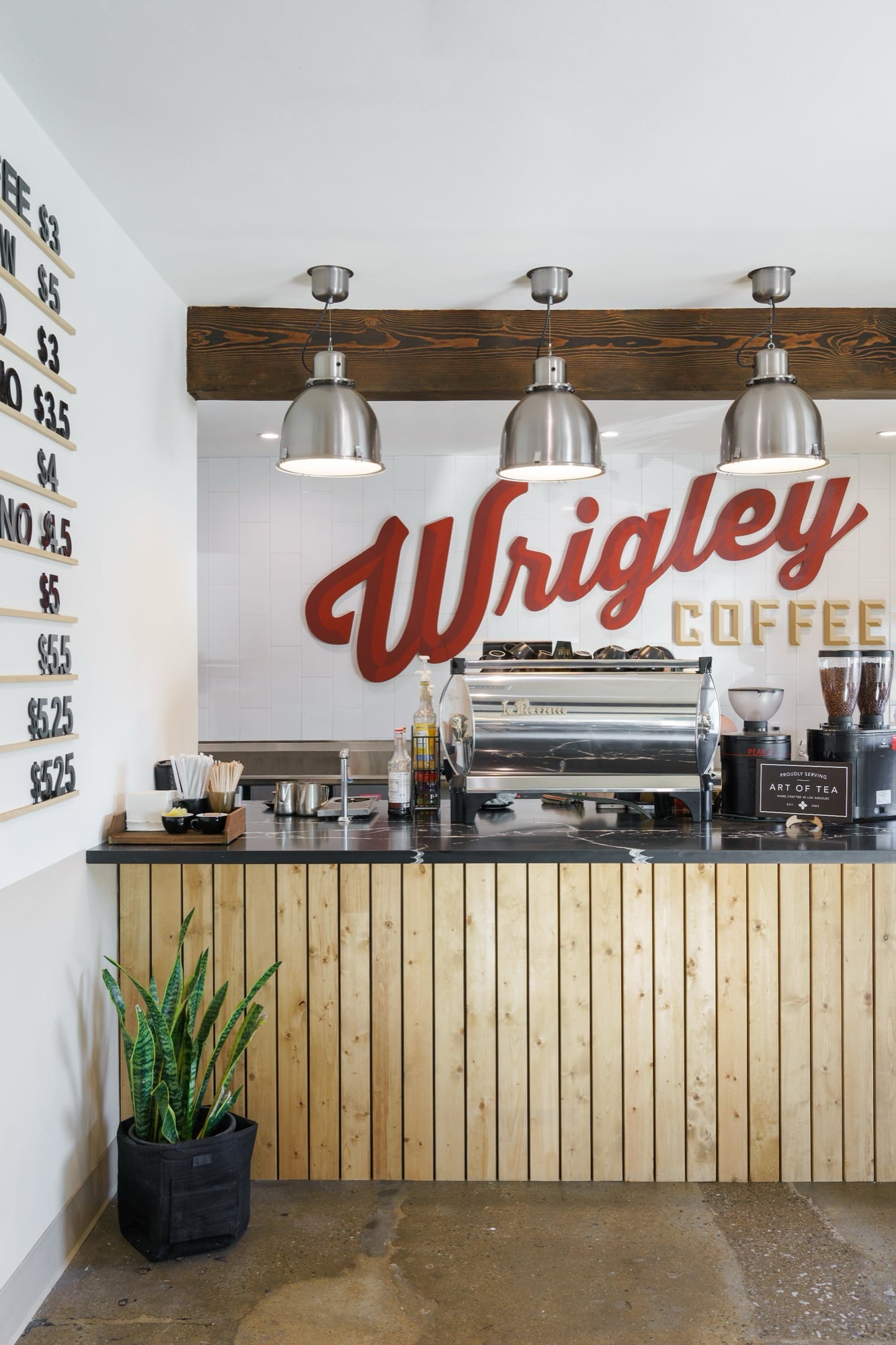 The espresso counter at Wrigley Coffee under a large red Wrigley Coffee sign